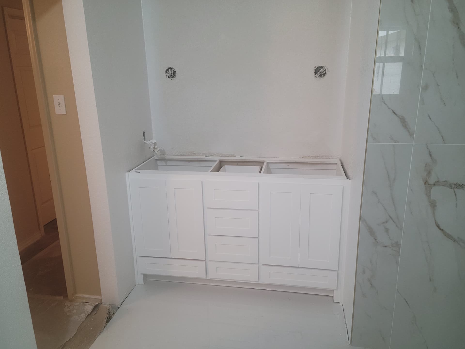 New white double-sink vanity cabinet installed during a bathroom remodel